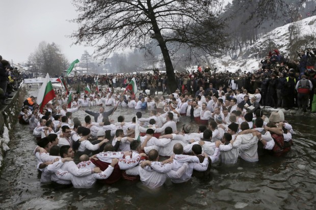 In Bulgaria, Bulgarians sing and dance in the icy waters of the Tundzha river, as they celebrate Epiphany day in the town of Kalofer, Wednesday, Jan. 6, 2016. Traditionally, an Eastern Orthodox priest throws a cross in the river and it is believed that the one who retrieves it will be healthy through the year. (AP Photo/Valentina Petrova)