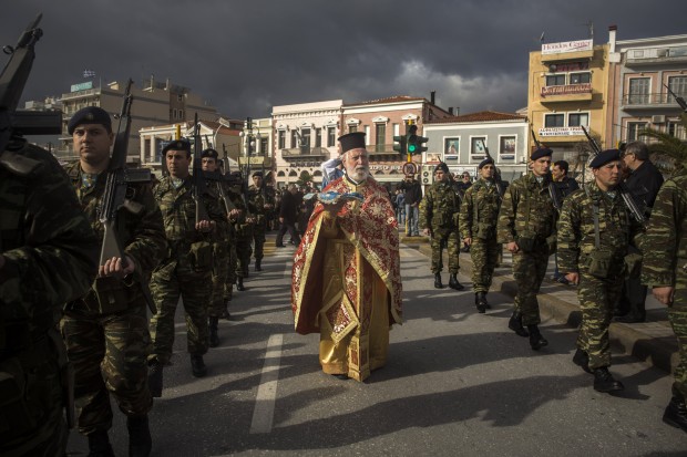 In Greece, an Orthodox priest holds a cross as he is accompanied by a guard of honor during an Epiphany ceremony to bless the water in Mytilene port on the northeastern Greek island of Lesbos. Similar ceremonies to mark Epiphany Day were held across Greece at the sea, rivers, lakes and dams. (AP Photo/Santi Palacios)