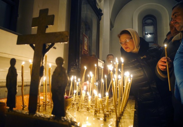 In Belarus, people light candles ahead of the Orthodox Christmas service in Minsk. (AP Photo/Sergei Grits)