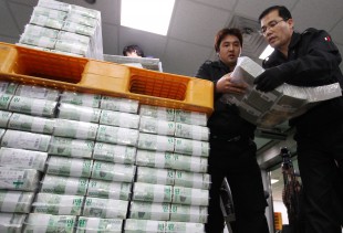 Workers of the Bank of Korea carry stacks of cash for delivery to commercial banks ahead of the Lunar New Year's holidays   (Xinhua/Park Jin-hee)