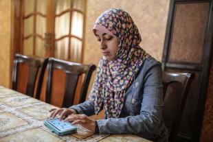 Palestinian college student Israa Al-ashqar ,23, works on an application on her mobile phone. 
(Xinhua/Wissam Nassar)