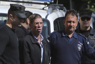 EgyptAir plane hijacking suspect Seif Eddin Mustafa, second left, is escorted by Cyprus police officers as he leaves a court after a remand hearing as authorities investigate him on charges including hijacking, illegal possession of explosives and abduction in the Cypriot coastal town of Larnaca Wednesday, March 30, 2016. Mustafa described as "psychologically unstable" hijacked a flight Tuesday from Egypt to Cyprus and threatened to blow it up. His explosives turned out to be fake, and he surrendered with all passengers released unharmed after a bizarre six-hour standoff. (AP Photo/Petros Karadjias)