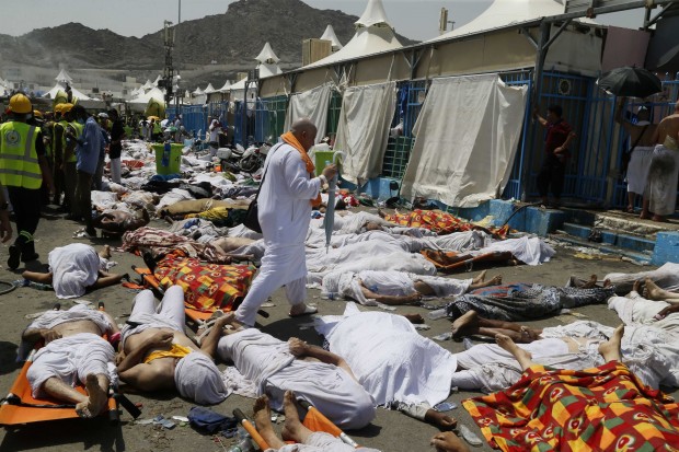 FILE - In this Sept. 24, 2015, file photo, a Muslim pilgrim walks through the site where dead bodies are gathered after a stampede during the annual hajj pilgrimage, in Mina, Saudi Arabia. The Saudi Gazette reported the kingdom has held a workshop to review hajj security plans following a deadly crush that killed more than 2,400 pilgrims last year. The newspaper reported that the three-day workshop, which ends Thursday, March 24, 2016, reviewed emergency medical plans and "the lessons of last year's hajj season." (AP Photo, File)