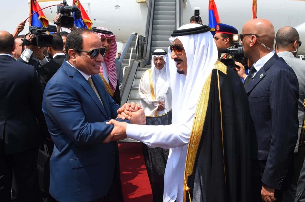 In this picture provided by the office of the Egyptian Presidency, Egyptian President Abdel-Fattah el-Sissi, left, shakes hands with Saudi Arabia's King Salman before he departs Egypt, Monday, April 11, 2016. Egypt's oldest secular university on Monday granted King Salman of Saudi Arabia an honorary doctorate for his "unique services" to Arabs and Muslims, the final function in a five-day visit clouded by opposition to Cairo's intention to hand over control of two Red Sea islands to Riyadh. (Sherif Abdel Minoem, Egyptian Presidency via AP)
