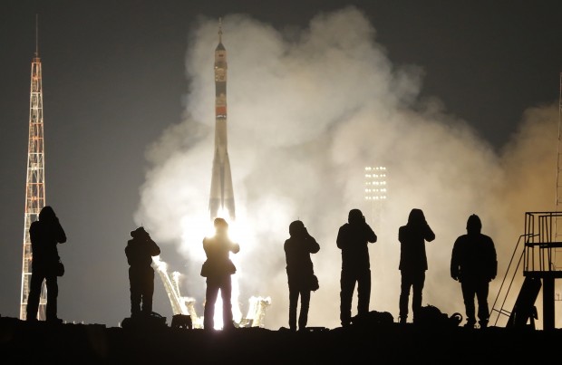 Journalists take photos of the Soyuz-FG rocket booster with Soyuz TMA-20M capsule carrying a new crew to the International Space Station, ISS, blasting off at the Russian leased Baikonur cosmodrome, Kazakhstan, Saturday, March 19, 2016. The Russian rocket carries NASA astronaut Jeff Williams, Russian cosmonauts Oleg Skripochka, and Alexei Ovchinin of Roscosmos. (AP Photo/Dmitri Lovetsky)
