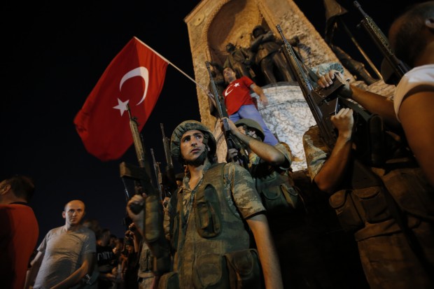 Turkish soldiers secure the area, as supporters of Turkey's President Recep Tayyip Erdogan protest in Istanbul's Taksim square, early Saturday, July 16, 2016. Turkey's armed forces said it "fully seized control" of the country Friday and its president responded by calling on Turks to take to the streets in a show of support for the government. A loud explosion was heard in the capital, Ankara, fighter jets buzzed overhead, gunfire erupted outside military headquarters and vehicles blocked two major bridges in Istanbul. (AP Photo/Emrah Gurel)
