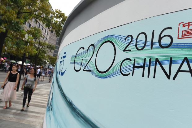 (160828) -- HANGZHOU, Aug. 28, 2016 (Xinhua) -- People walk past a G20 themed poster in Hangzhou, capital of east China's Zhejiang Province, Aug. 27, 2016. The 11th G20 summit will be held from Sept. 4 to 5 in Hangzhou. (Xinhua/Ju Huanzong) (yxb)