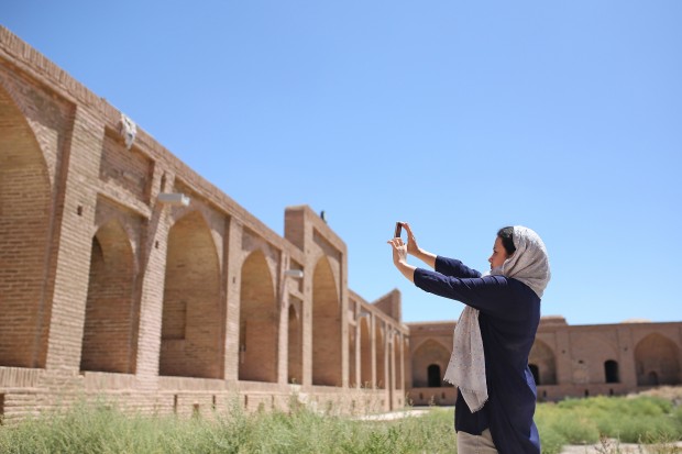 (160816) -- SEMNAN, Aug. 16, 2016 (Xinhua) -- A tourist takes pictures of a historical Caravanserai in Semnan province, Iran, Aug. 15, 2016. The complex of Miandasht Caravanserai contains several extraordinary buildings, including three Caravanserais, three traditional water stores, one place for hours hosting and one castle, with total area of 15,000 square meters. (Xinhua/Ahmad Halabisaz) (cyc)
