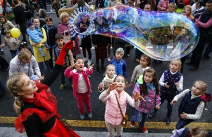 A street performer creates a soap bubble for children  during celebrations marking the Day of the City in Moscow downtown, Russia, on Saturday, Sept. 10, 2016. Moscow's official history marks Saturday as it's 869th anniversary. (AP Photo/Pavel Golovkin)