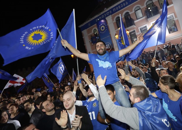 Supporters of ruling Georgian Dream party take part in rally in Tbilisi, Georgia, Saturday, Oct. 8, 2016. Two exit polls in Georgia's parliamentary election show the ruling party in the lead, but the polls differ sizeably on the margin of victory. (AP Photo/Sergei Grits)