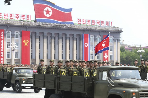 In this July 27, 2013, photo, North Korean soldiers turn and look towards leader Kim Jong Un as they carry packs marked with the nuclear symbol as they parade during a ceremony marking the 60th anniversary of the Korean War armistice in Pyongyang, North Korea. North Korea’s torrent of weapons tests in 2016 has strengthened Pyongyang militarily, but the real reason behind the rush is the U.S. presidential elections, according to a growing number of experts on North Korea. Kim Jong Un has forged an increasingly sophisticated arsenal. There have been truck-launched missile tests, two nuclear explosions, experiments with powerful rocket engines and more than a dozen other major missile trials. (AP Photo/Wong Maye-E)