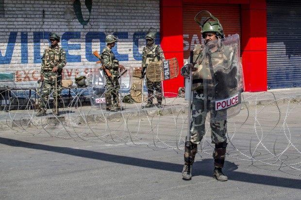 Indian paramilitary soldiers stands guard at an temporary checkpoint during curfew in Srinagar, Indian controlled Kashmir, Monday, Oct. 10, 2016. Authorities in Indian portion of Kashmiri imposed restrictions in some parts of Srinagar fearing religious processions marking the Muslim month of Muharram would turn into anti-India protests. (AP Photo/Dar Yasin)