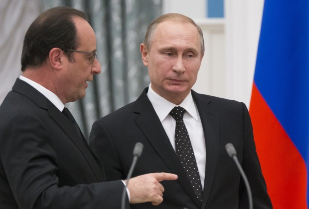 FILE- In this file photo taken on Thursday, Nov.  26, 2015, Russian President Vladimir Putin, right, listens as France's President Francois Hollande speaking to him as they leave their news conference following talks in Moscow, Russia. Amid a bitter rift over Syria, Russian President Vladimir Putin indefinitely postponed a visit to France after Paris had revised its program and said it would talk about nothing else but the Syrian crisis. (AP Photo/Alexander Zemlianichenko, Pool, File)