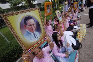Thais pray while holding up portraits of Thailand's King Bhumibol Adulyadej at Siriraj Hospital where the king is being treated in Bangkok, Thailand, Wednesday, Oct. 12, 2016. Thailand’s stock market and currency have tumbled and the prime minister has canceled an overseas trip Wednesday amid concerns about long-ailing Bhumibol’s health. His son, the crown prince, returned home from Germany. (AP Photo/Sakchai Lalit)