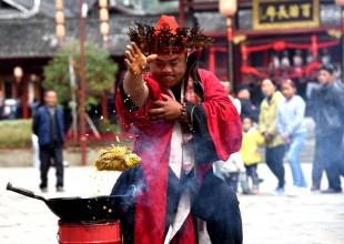 TONGREN, Oct. 16, 2016 (Xinhua) -- A man of Miao ethnic group performs boiling oil pan magic during a cultural tourism festival in Zhengda Town of Songtao Miao Autonomous County, southwest China's Guizhou Province, Oct. 16, 2016.  Local people held various folk activities on the festival Sunday.   (Xinhua/Long Yuanbin) (wx)