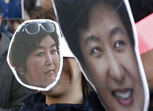 In this Wednesday, Nov. 2, 2016, file photo, South Korean protesters wearing masks of South Korean President Park Geun-hye, right, and her confidante Choi Soon-sil, who is at the center of a political scandal, attend a rally calling for Park to step down in downtown Seoul. A scandal that has captivated a nation took a new twist this weekend when prosecutors directly linked South Korea's president to alleged misdeeds by a shadowy confidante seen as pulling government strings. With hundreds of thousands taking to the streets each weekend in anger, President Park Geun-hye is digging in her heels, refusing to meet with prosecutors. The looming question now is: Will legislators take the politically risky path of impeaching her? (AP Photo/Ahn Young-joon, File)