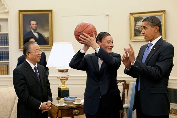Chinese Vice Premier Wang Qishan, center, holds the autographed basketball given to him by President Barack Obama following their Oval Office meeting Tuesday, July 28, 2009, to discuss the outcomes of the first US–China Strategic and Economic Dialogue. Looking on at left is Chinese State Councilor Dai Bingguo.