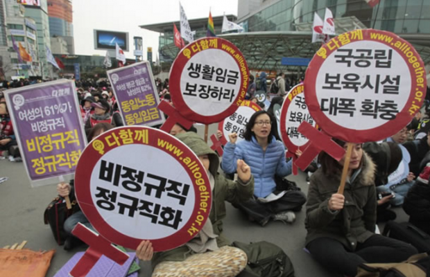 “South Korean female workers shout slogans during a rally to mark International Women's Day in Seoul, South Korea, Thursday, March 8, 2012. The letters read "Preserve a living wage and hire more temporary employees."