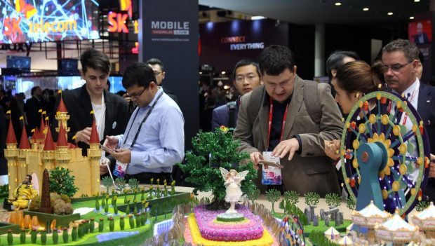 Visitors try newly-released smart phones made by Chinese manufacturer ZTE at the Mobile World Congress held in Barcelona, Spain in February, 2017. (Photo by Wang Di from People’s Daily)