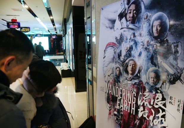 People watch a poster of Wandering Earth at a movie theater of Nantong, eastern China’s Jiangsu province, February.10, 2019. (Photo/CFP)