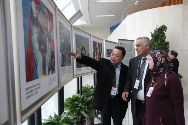 Representatives from foreign political parties watch pictures at a photo exhibition showcasing Xinjiang’s sceneries in Urumqi, capital city of northwest China's Xinjiang Uygur Autonomous Region, February 27, 2019. (Photo by Wang Hailin, People’s Daily)
