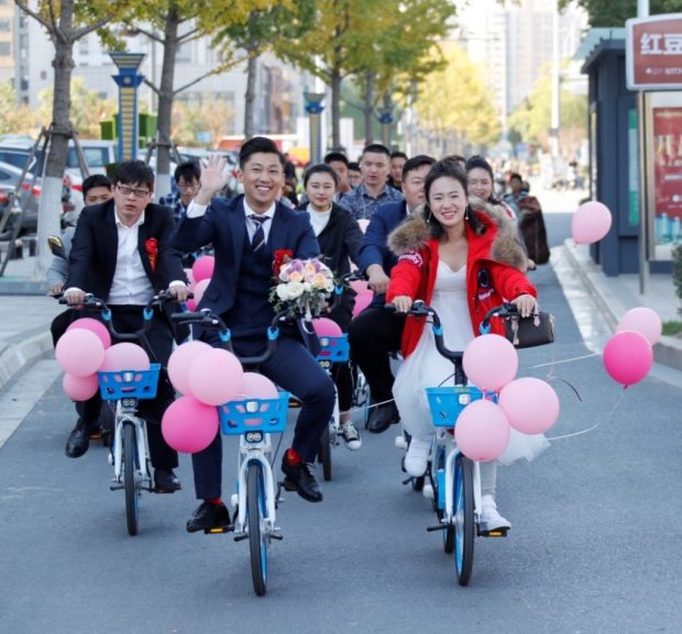 A couple uses shared bikes instead of cars on their wedding day in Huai’an, east China's Jiangsu Province, October 27, 2018. (Photo: People’s Daily Online)