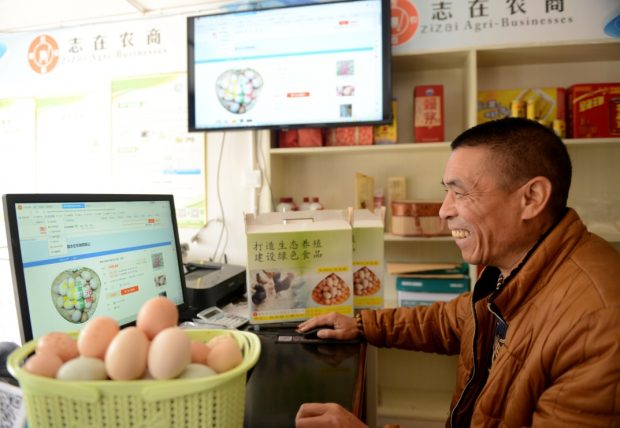On November 19, 2018, in the e-commerce service station of Gulougou Village, Peng'an County, Sichuan Province, a staff is busy picking up agricultural and sideline products purchased from poor households, which would be sold through e-commerce channels after packaging. (Guo Anping Zhou Liang / People’s daily online