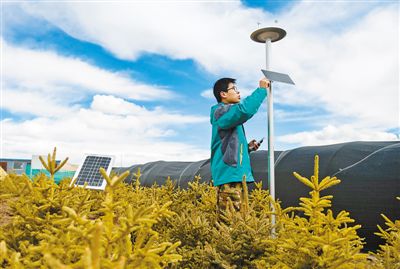 An engineer checks big data automatic monitoring equipment at a weather station in the experimental base of a pilot planting project. Photo by Liu Dongjun from Xinhua News Agency