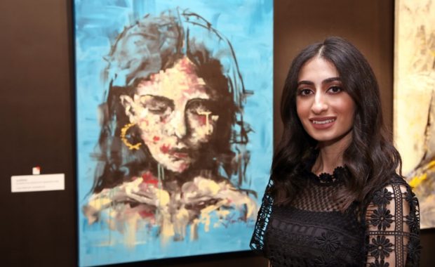 Layal Al Thawadi next to her favorite artwork