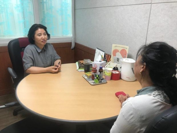 Counselor Park Kyung-hui (L) talks with a N.K. defector (Yonhap)