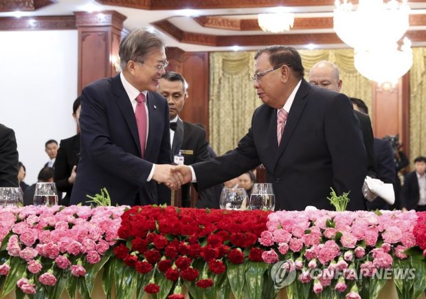 President Moon Jae-in shakes hands with his Laotian counterpart, Bounnhang Vorachith in Vientiane on Sept. 5, 2019. (Yonhap)