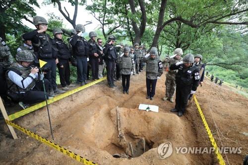 Defense Minister Jeong Kyeong-doo (2nd from R) salutes before the remains of a South Korean soldier killed in the 1950-53 Korean War inside the Demilitarized Zone (DMZ) on June 11, 2019. (Yonhap)