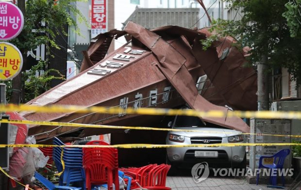 A spire from a church in Seoul lies on the top of a parked vehicle (Yonhap)