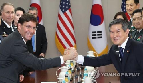 South Korean Defense Minister Jeong Kyeong-doo (R) and U.S. Secretary of Defense Mark Esper clasp hands during their talks at the defense ministry in Seoul on Aug. 9, 2019. (Yonhap)