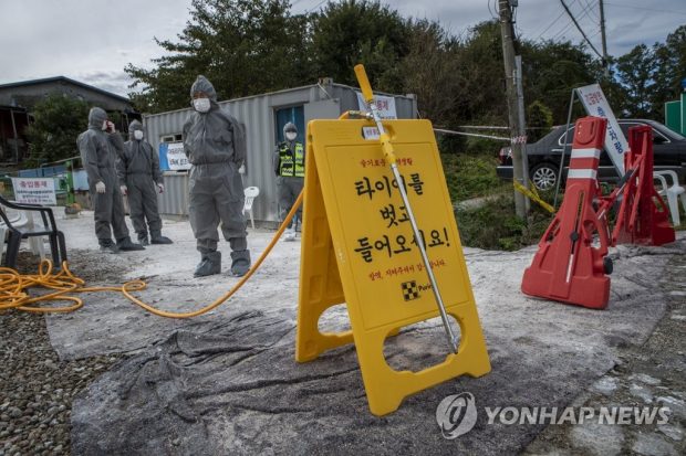 Quarantine officials set up a sign at a pig farm in Paju, north of Seoul, on Oct. 3, 2019, as they carry out disinfection operations against African swine fever. (Yonhap)
