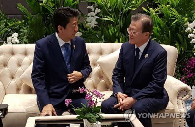 Moon Jae-in (R) talks with Abe on the sidelines of the 22nd ASEAN Plus Three summit in Bangkok on Nov. 4, 2019 (Yonhap)