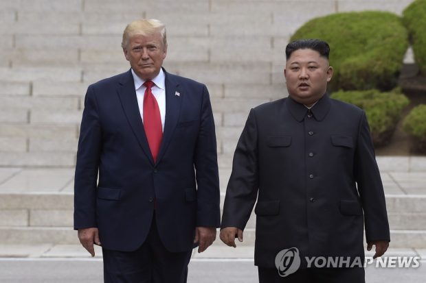 This Associated Press file photo from June 30, 2019, shows U.S. President Donald Trump (L) standing with North Korean leader Kim Jong-un at the North Korean side of the border village of Panmunjom. (Yonhap) 