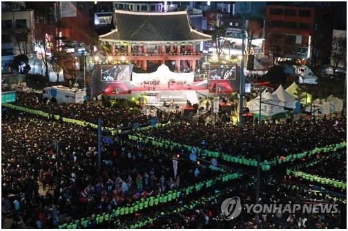 People gather in front of the Bosingak Belfry in central Seoul on Dec. 31, 2019, to watch the traditional bell-ringing ceremony that takes place at midnight. (Yonhap)