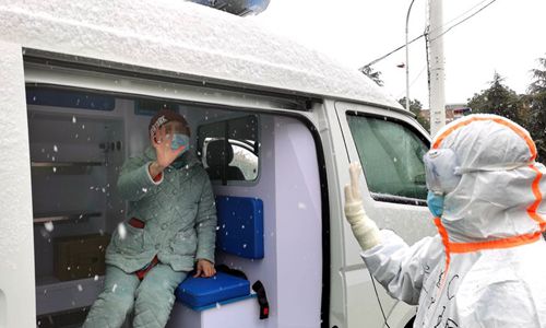 A cured COVID-19 patient waves goodbye to a medical worker at the "Wuhan Livingroom" makeshift hospital in Wuhan, central China's Hubei Province, Feb. 15, 2020. (Photo: Xinhua)