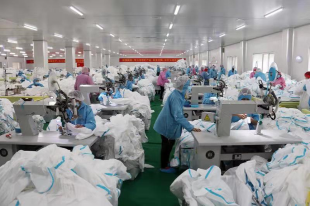 Photo taken on Feb. 8 shows workers busy with production of medical protective supplies in a workshop of a local company in Xiantao, central China’s Hubei Province. (Hou Linliang/People’s Daily)