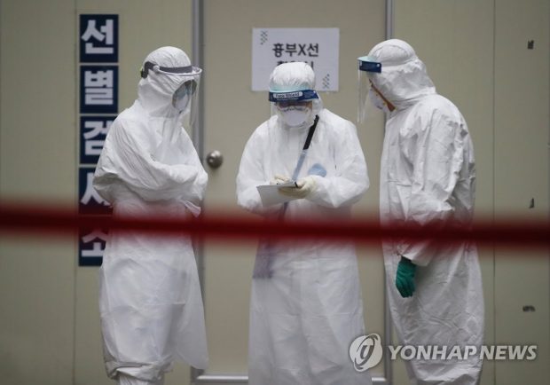 Medical workers in protective gear make preparations in front of a testing facility at a hospital in the virus-hit city of Daegu on March 26, 2020. (Yonhap)
