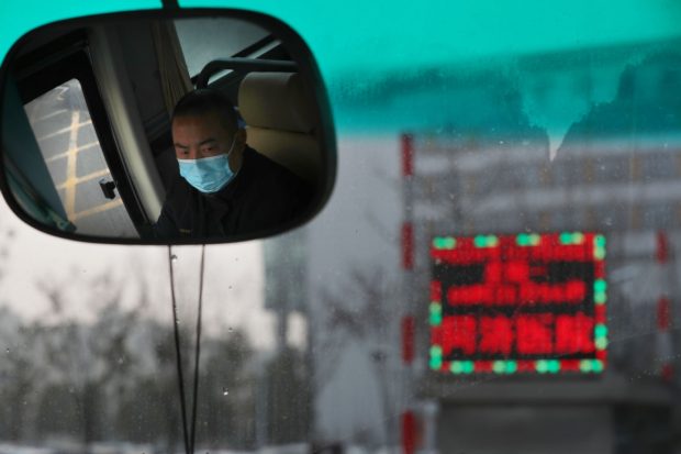 Bus driver Wang Mian transports medical workers to Tongji Hospital, which provides hundreds of beds for patients infected by the virus. [Photo by Zhu Xingxin/China Daily])