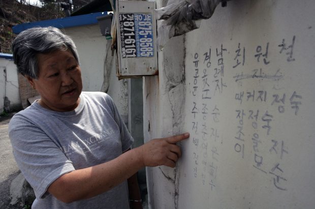 A grandmother in sub-beolgiji village points to the names of the people she was with.