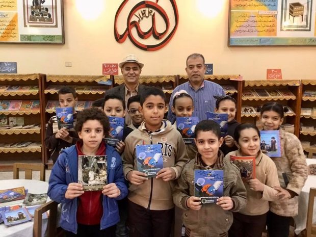 Writer, top left, visits his primary school; Abdul-Monem Riyadh, Benha, with students holding some of his books for children
