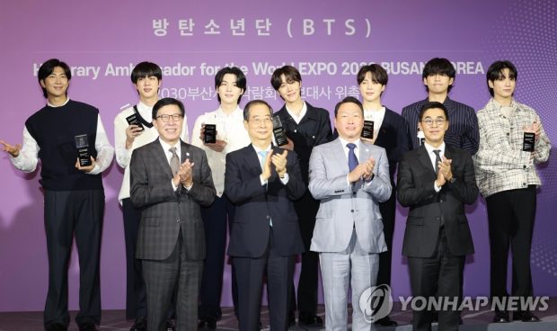 BTS posing for photos after being named public relations ambassadors for Busan's bid to host the 2030 World Expo. (Yonhap)