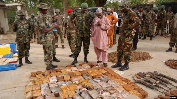 Military officials stand near ammunitions seized from suspected 