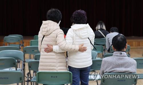 People wait at a community service center near the site of the Itaewon stampede 