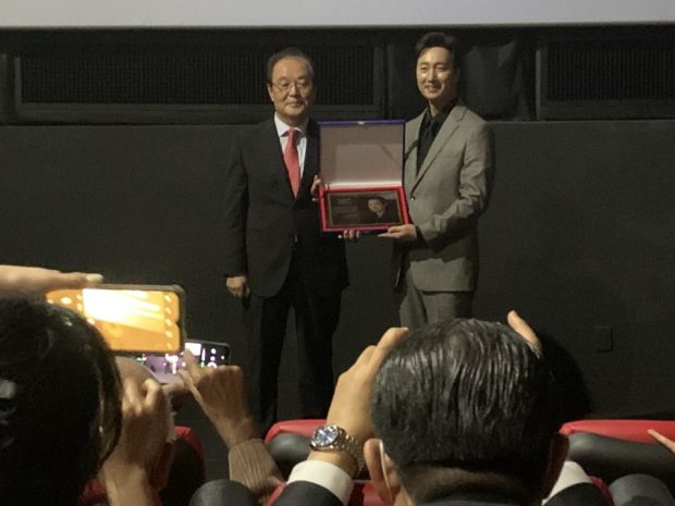 Koo Bon-hong, chairman of the Asia Journalists Association (left), hands over a commemorative copper plate for the AJA Award 2022 to actor Park Hae-il. 