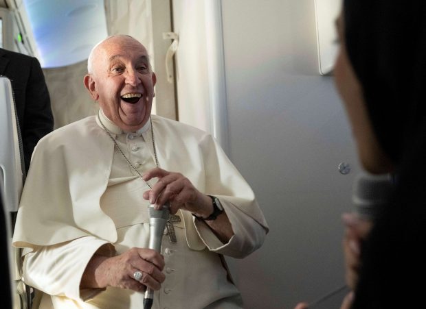 Pope Francis smiles with Fatima Khaled Al Najem, Bahrain News Agency reporter, during his flight back to Rome, after his apostolic journey to Bahrain, November 6, 2022. Maurizio Brambatti/Pool via REUTERS