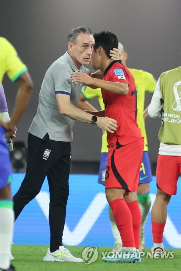  Bento (L) embraces midfielder Lee Kang-in following their 4-1 loss to Brazil in the round of 16 at the FIFA World Cup at Stadium 974 in Doha on Dec. 5, 2022. (Yonhap)